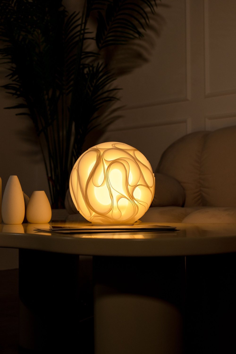 A glowing round Tiziri lamp on a low table in a dim living room