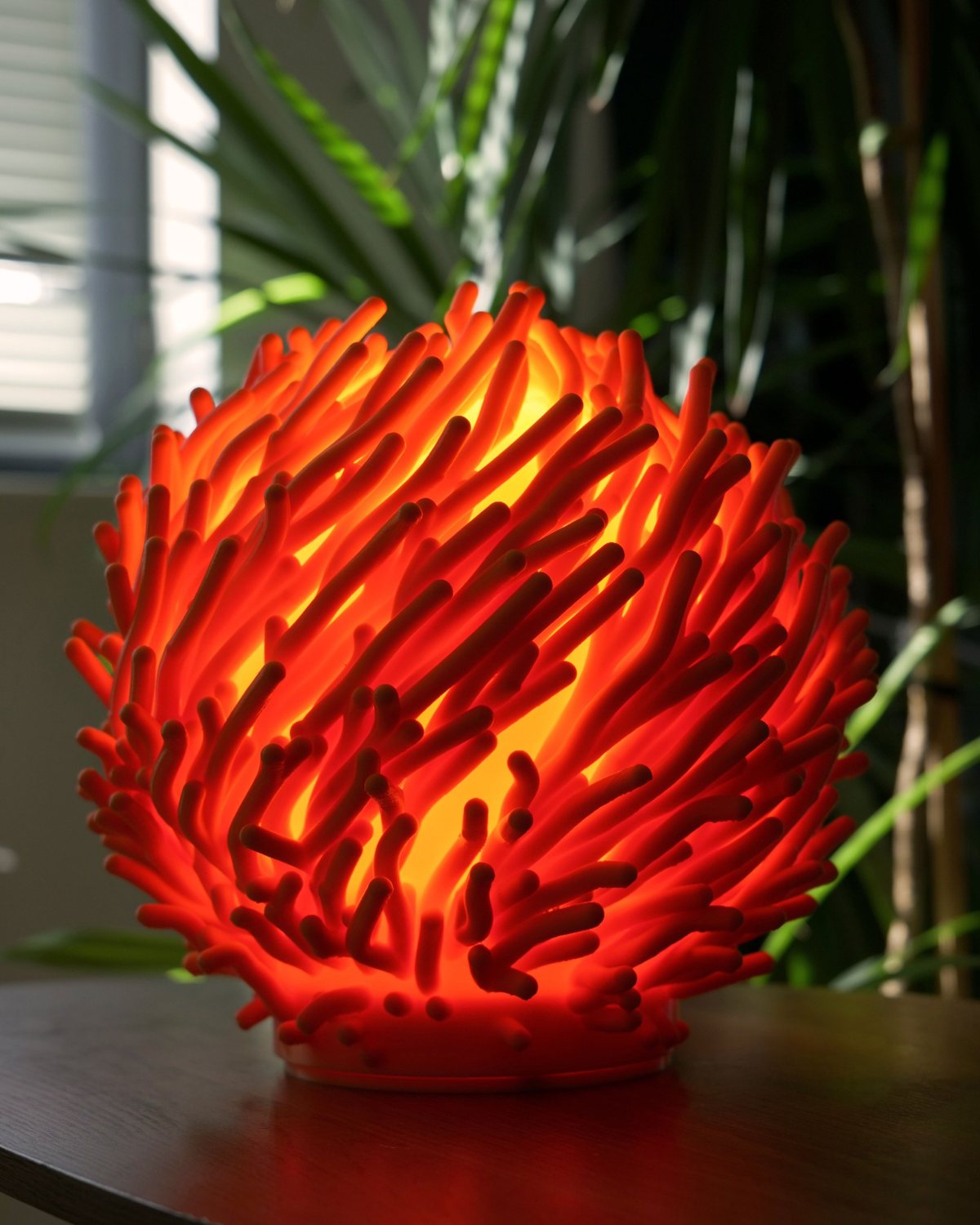 Marjan lamp in coral orange, glowing among palm leaves